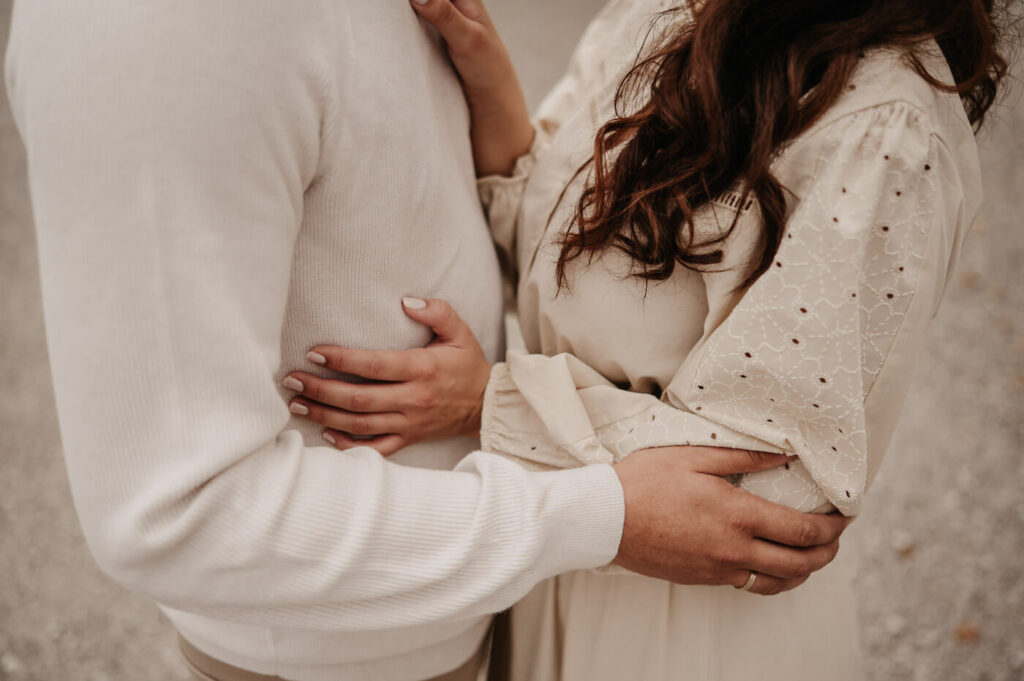 Detailaufnahme der Hände: Ein Paar steht sich beim Paarshooting gegenüber