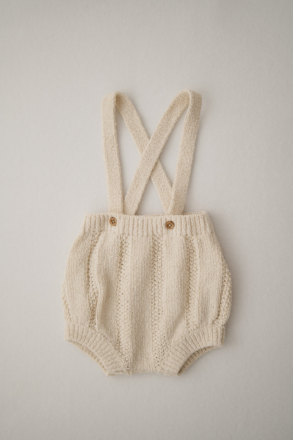 Ein beiger Strampler für Newbornshootings