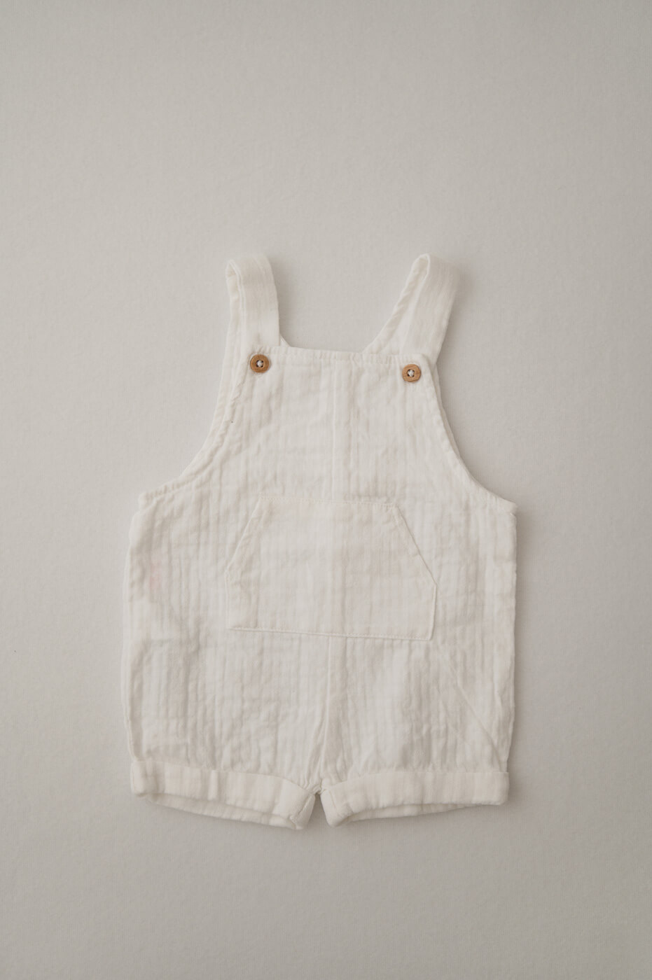 Ein weißer Musselin-Strampler für Newbornshootings