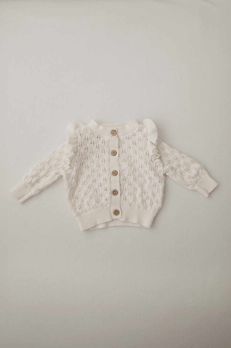 Eine weiße Strickjacke für Newbornshootings