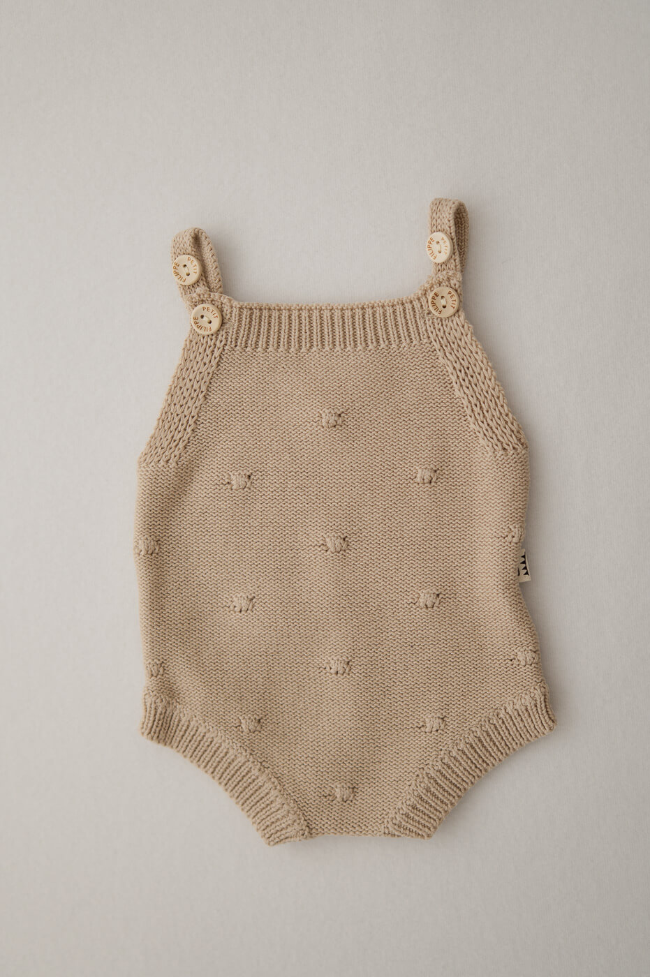 Ein hellbrauner Strampler für Newbornshootings