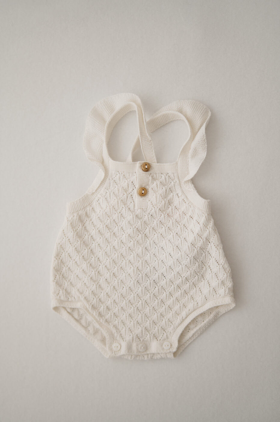 Ein weißer Strampler für Newbornshootings