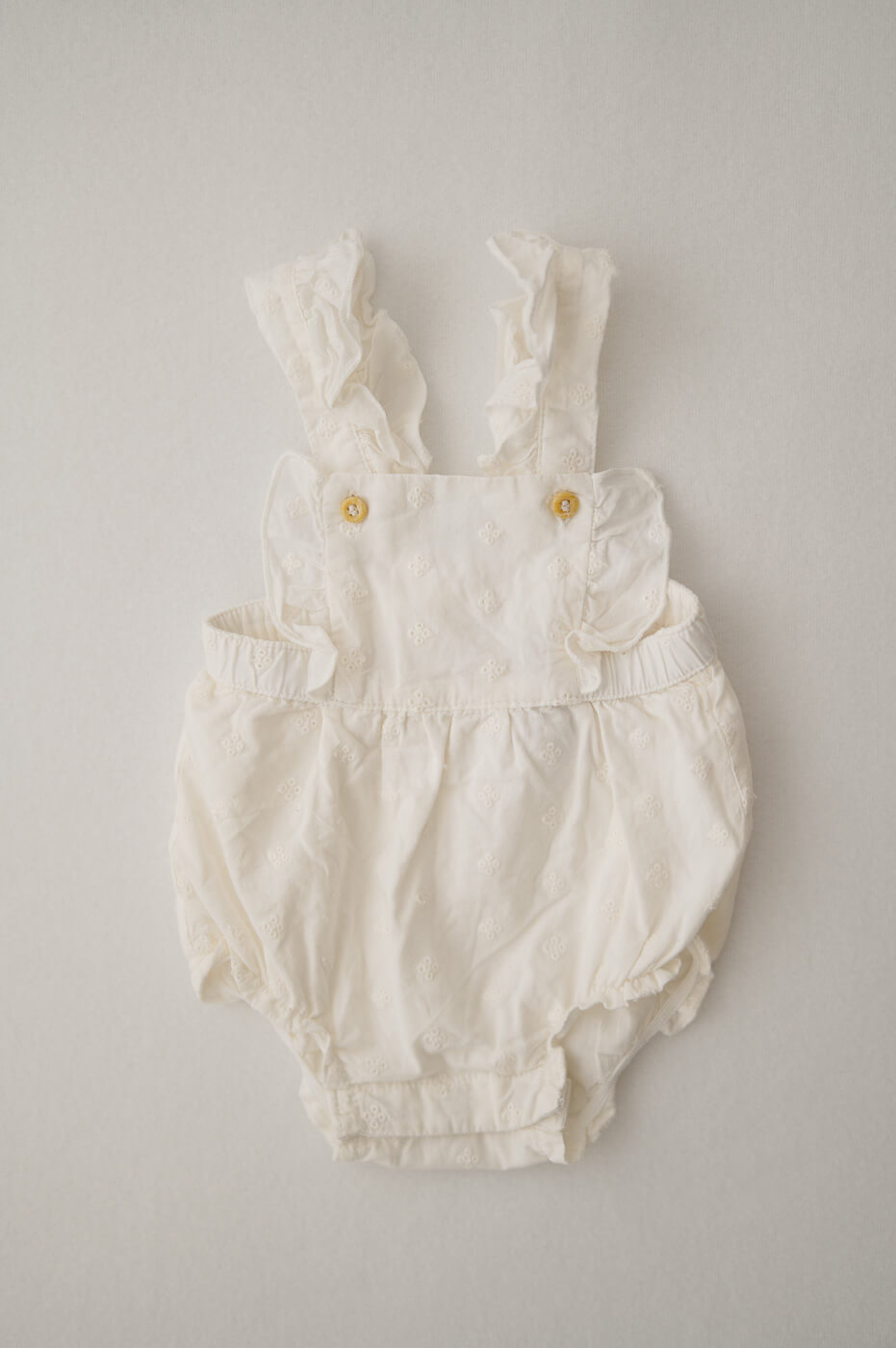 Ein Strampler in creme mit Rüschen für Newbornshootings